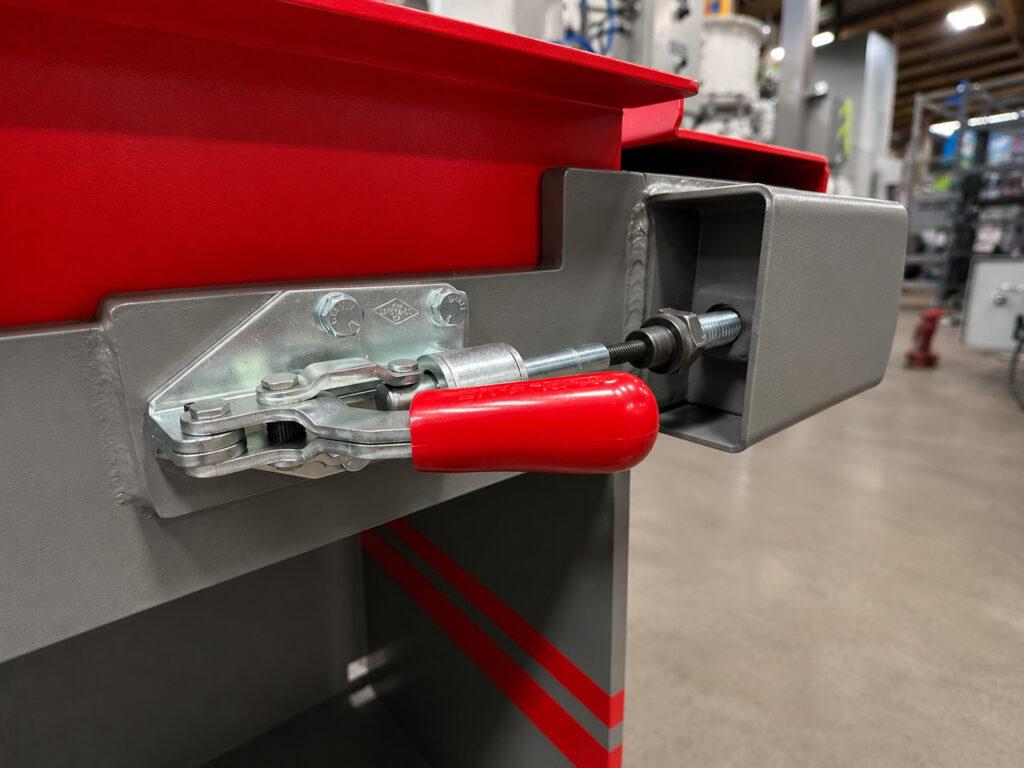 Close-up of the removable belt latch on a Winona Van Norman Platen Grinder allowing quick replacement and maintenance of the grinding belt.