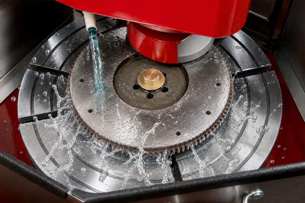 Winona Van Norman Flywheel Grinder resurfacing a flywheel with visible grinding sparks during an active machining operation.