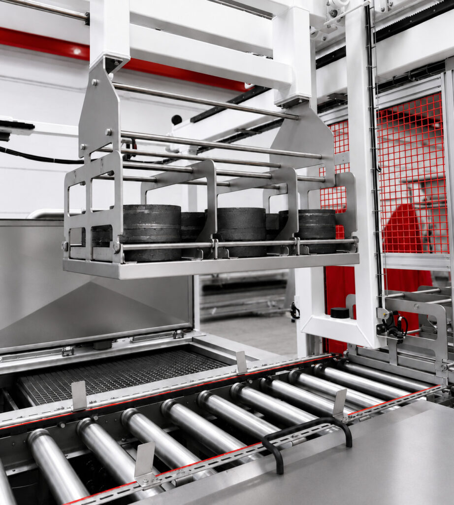 Close-up of the automated handling system on a Winona Van Norman Ultrasonic Washer designed to automate the loading and transfer of engine components and precision parts.