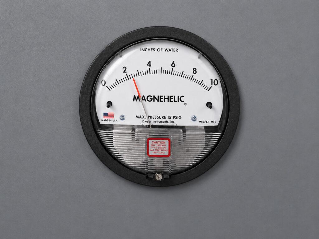 Close-up of the Magnehelic meter on a Winona Van Norman Grinding Bench used to monitor system pressure for optimal performance.