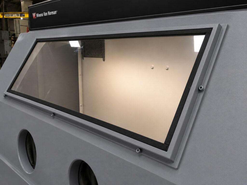 Close-up of the viewing window on a Winona Van Norman GB601 Glass Bead Blaster providing clear visibility during blasting operations.