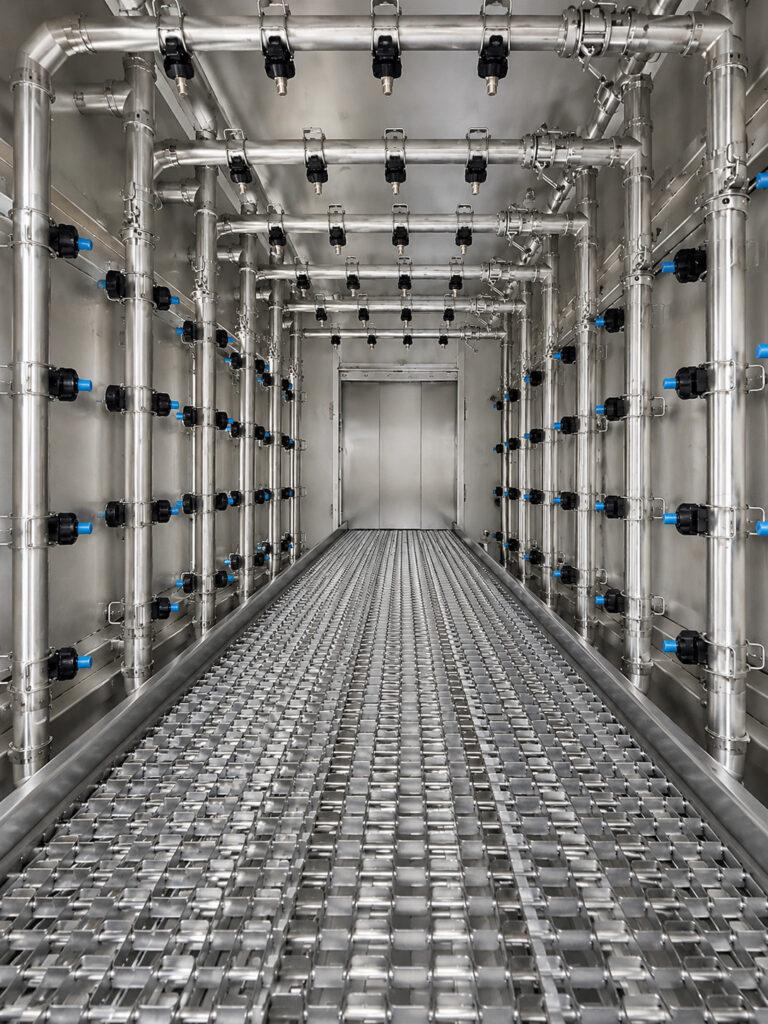 Interior view of a Winona Van Norman Flow Through Washer showing the high-pressure spray nozzles used to clean engine components.