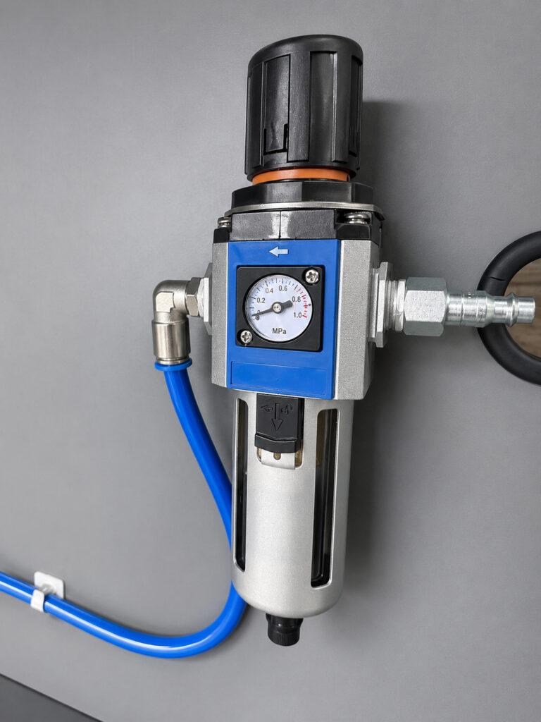 Close-up of the pressure gauge on a Winona Van Norman Automated Crankshaft Polisher used to monitor polishing system performance during operation.