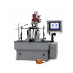 Slight angle view of a Winona Van Norman Crankshaft Balancer featuring precision roller supports, measuring system, operator controls, and heavy-duty construction for accurate crankshaft balancing.